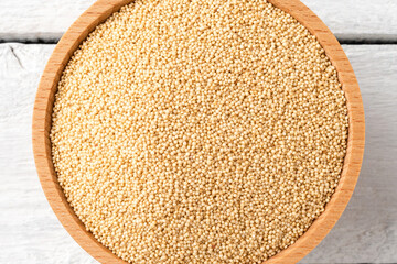 Amaranth seeds in bowl on rustic wooden table. Top view