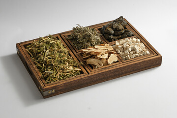 Some types of herb are placed on a wooden tray with five compartments. Herbs are a natural approach to prevention, healing and health support