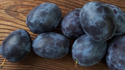Tasty and ripe plums on brown wooden table