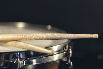 Obraz na płótnie Canvas Close-up, snare drum and drumsticks on a dark background.