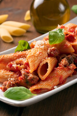 Piatto di deliziosa pasta condita con ragu di salsiccia, cibo italiano 