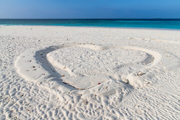 heart shape in white sand on tropical beach