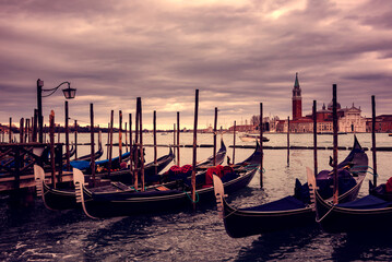 Fototapeta na wymiar Gondolas in Venice on sunset next to San Marco square. Famous landmark in Italy