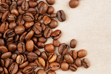 roasted whole arabica coffee beans, scattered on paper, isolated