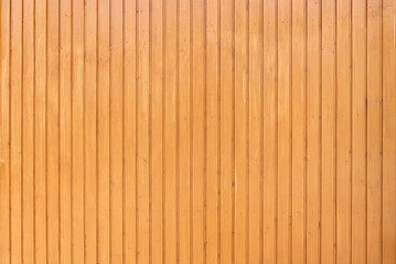 Hell honigfarben lasierte Holzwand aus genagelten vertikalen Brettern