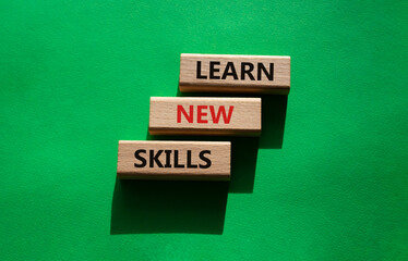 Learn new skills symbol. Concept words Learn new skills on wooden blocks. Beautiful green background. Business and Learn new skills concept. Copy space.