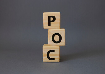 POC - Proof of Concept symbol. Wooden cubes with words POC. Beautiful grey background. Business and POC concept. Copy space.