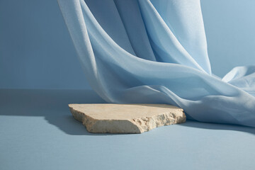 A broken stone podium displayed on a light blue background, decorated with a luxurious fabric....