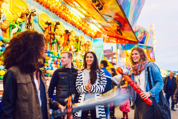 Friends playing with inflatable toys in amusement park