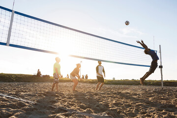 Friends playing volleyball on beach