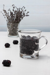 Blackberry summer drink in a glass mug. Lavender in glass.
