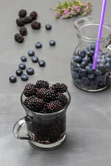 Blackberry in a glass mug. Blueberries in a jug.