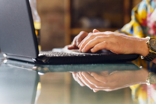 Woman using laptop in bakery - Powered by Adobe