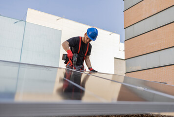 A technician installing solar panels on the roof of a building, concept of economical energy and sustainability, small own business