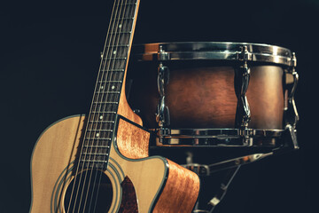 Acoustic guitar and snare drum on a black background isolated.