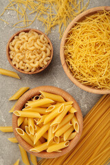 Various types of Italian pasta on grey background