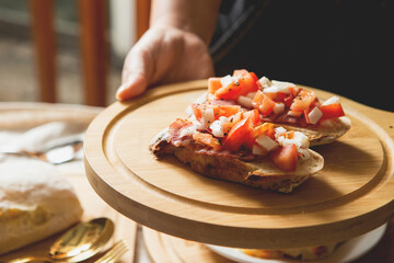 Open sandwich on cutting board, various desserts on table