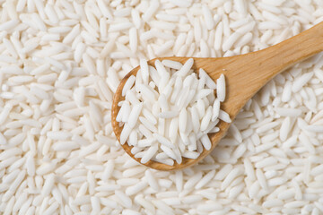 Organic glutinous rice or sticky rice in spoon background.