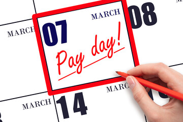 Hand writing text PAY DATE on calendar date March 7 and underline it. Payment due date