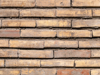 A rough, brown brick wall closeup. Textured background with space for text.