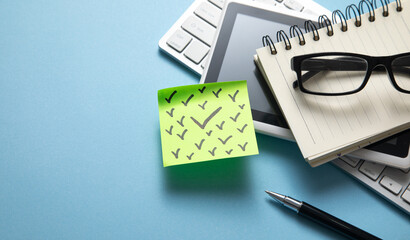 Check marks on sticky note with a business objects on the blue background.