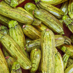 Fresh organic zucchini top view close up for sale at the local market. Green, vegan food background.