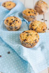 Classic muffins with chocolate chips for breakfast on blue and white background close up selective focus