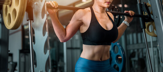 Concepts healthy lifestyle and workout. Muscular Building, Workout, Fitness muscular body, Fitness, Gym. Fitness asian woman doing exercise and lifting barbell weights in sport gym.