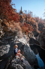 Active lifestyle. Trekking and hiking. Young woman with rucksack in the forest rock canyon.