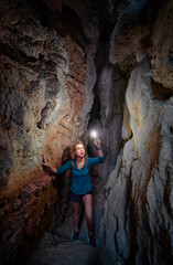 Young woman exploring a cave digged in the mountain.