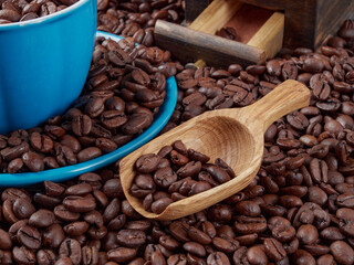 Antique vintage retro bronze coffee mill on black wooden board with roasted coffee beans