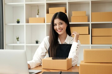 Fototapeta na wymiar Small business entrepreneur SME freelance woman working at office, BOX,tablet and laptop online, marketing, packaging, delivery, e-commerce concept..