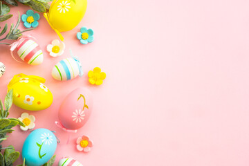 Easter background with holiday decorations. Eggs, spring leaves and flowers on pink. Flat lay with copy space.