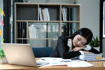 Tired businesswoman sleeping with document on the desk at office. Overwork, working overtime and stress at work concept. - obrazy, fototapety, plakaty
