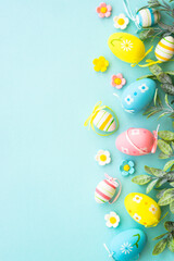 Easter background or greeting card on blue. Eggs, spring leaves, flowers and colored butterflies. Flat lay with copy space.