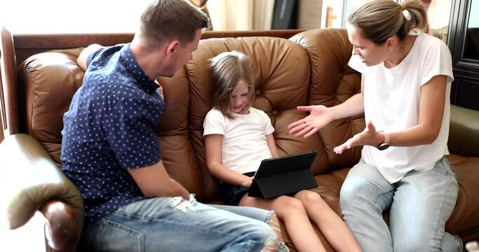 Angry parents scold schoolgirl addicted from tablet on sofa