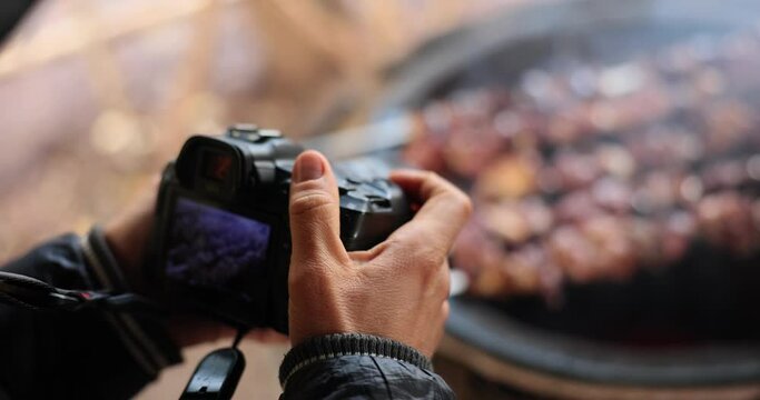 Man takes picture of delicious shashlik cooked on grill