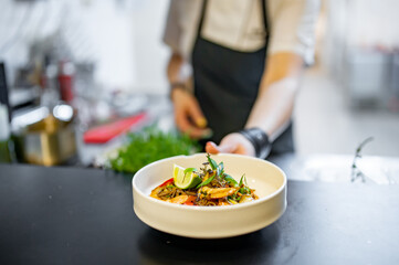 Chef cooking Stir fry noodles with vegetables and shrimps on restaurant kitchen