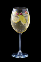 Cold white sangria with dry rosebuds in wine glass isolated on black