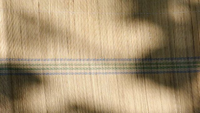 Summer scene, moving shadow on the  bamboo mat ,rug. Relaxing in the shade, enjoying nature