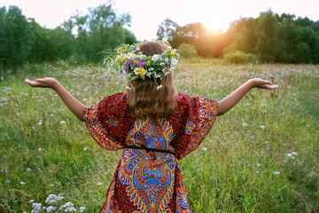 girl in flower wreath on green meadow, abstract natural background. Floral crown, symbol of summer solstice. Midsummer, wiccan Litha sabbat. pagan slavic holiday Ivan Kupala. wellbeing prayer - obrazy, fototapety, plakaty