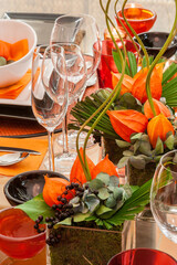 orangene Tischdekoration mit Pflanzen und Bl&auml;ttern