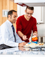 Gay Lifestyle: Serving Breakfast. A same sex, mixed race couple enjoying breakfast together in their modern home. From a series of related images.