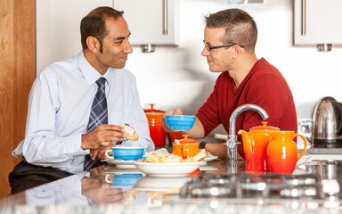 Gay Lifestyle: Breakfast Time. A same sex, mixed race male couple enjoying breakfast together in their modern home. From a series of related images.