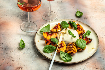 Gourmet Roasted Peaches with Burrata soft cheese, basil and drizzled with honey, with rose wine. Antipasto Dinner or aperitivo party