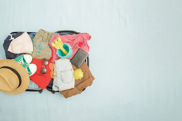 Open suitcase and luggage with various packed clothes. Travel concept. Top view, copy space