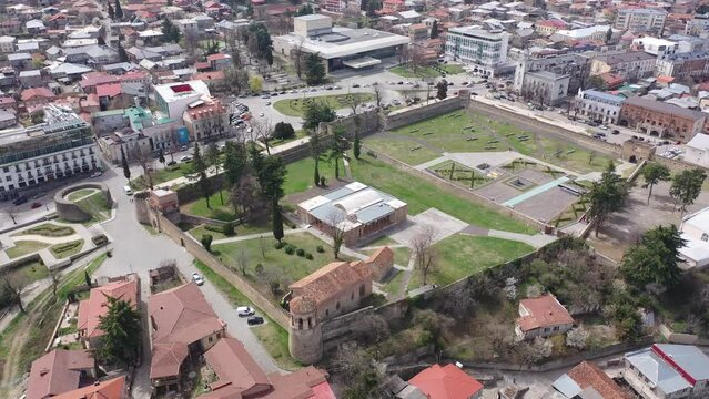 Scenic view from drone of central areas of Telavi city overlooking medieval walled Batonis Tsikhe fortress on spring day, Georgia