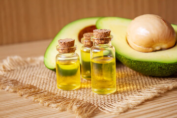 Avocado and avocado oil on wooden background. Selective focus