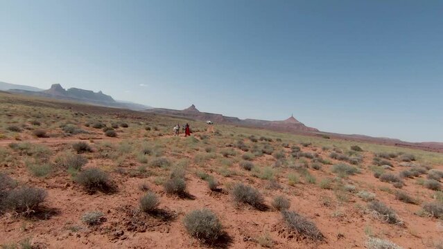 A couple carries the drones between the red rocks, streams and indigenous lands of the desert while having fun and enjoying the adventure with pyramids in the background. Utah