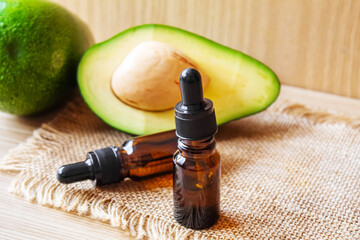 Avocado and avocado oil on wooden background. Selective focus